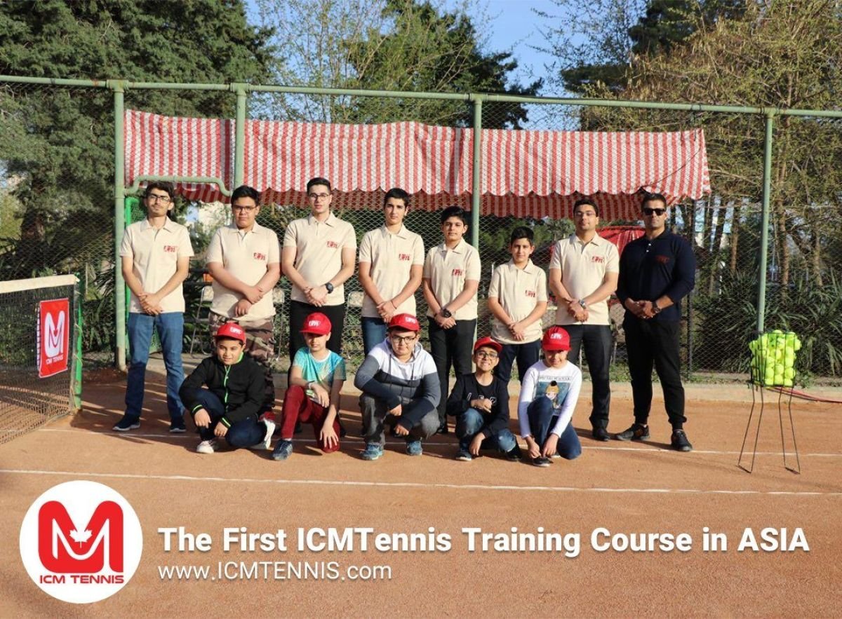Players in matching uniforms with their coach on a clay court at the first ICM Tennis training course in Asia.