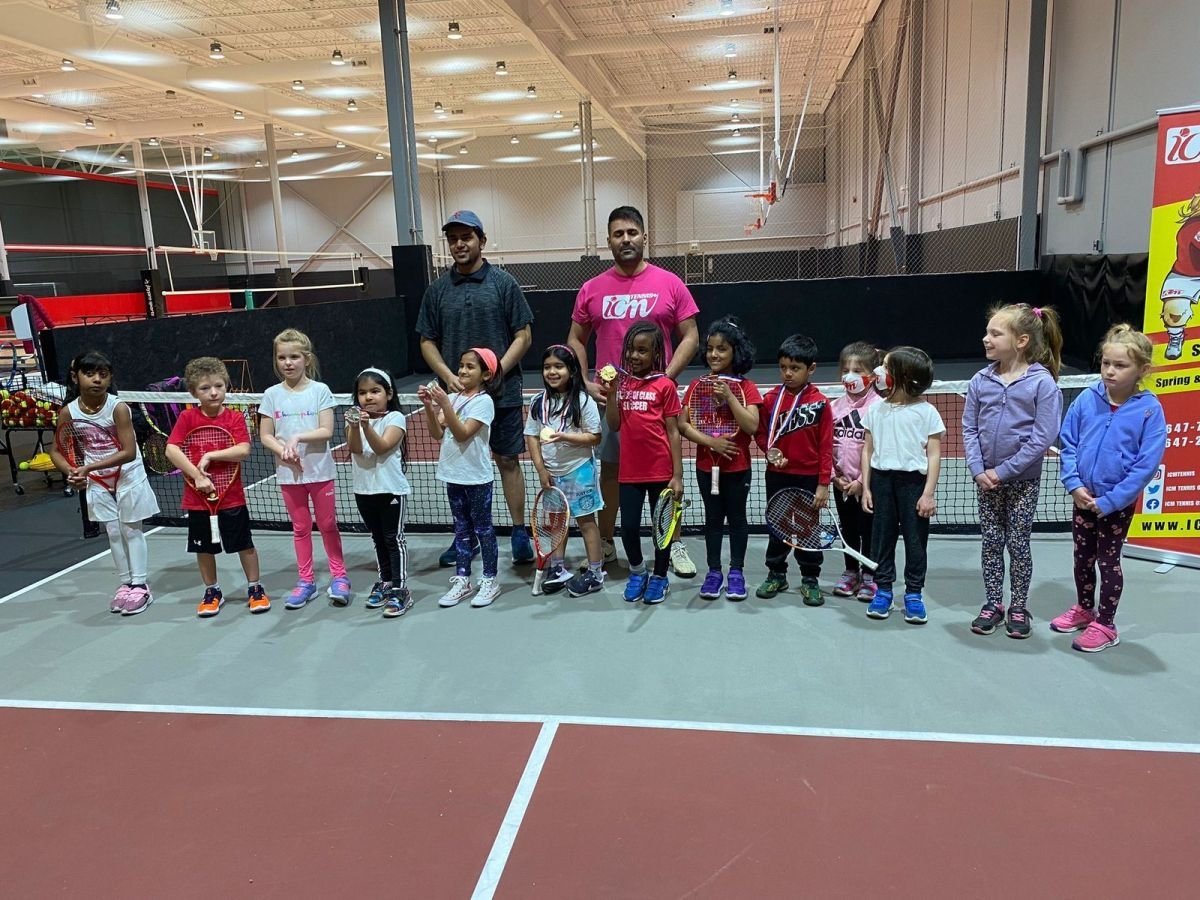 Young players and two coaches lined up at the net after the under 8 tournament.