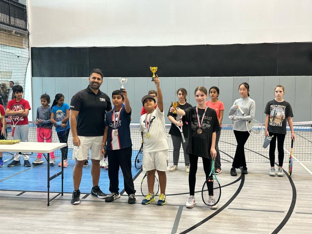 Director Mahdi Taheri with young players holding trophies after an ICM tournament in Oshawa.