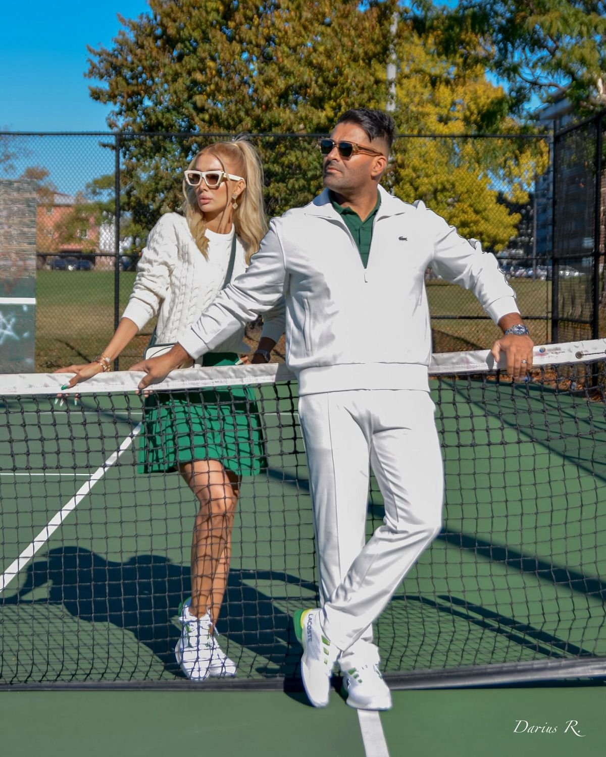 Mahdi Taheri, founder and director of ICM Tennis, leaning on a tennis net on an outdoor court